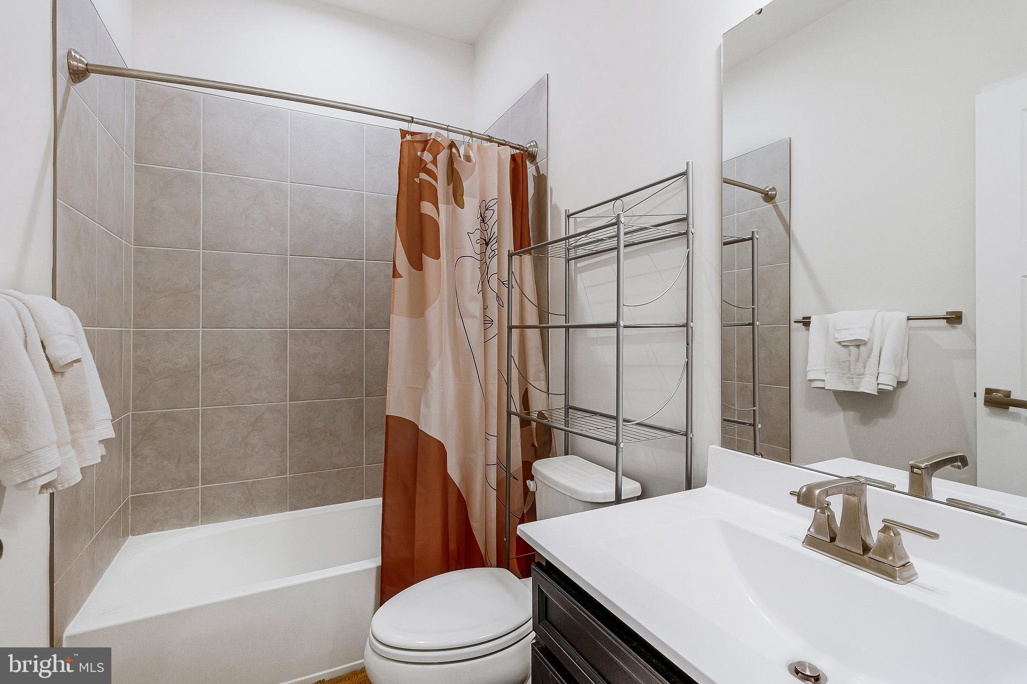 16504 Caribbean Way Accokeek, MD 20607 - Photo 17 of 29 a bathroom with a sink toilet and shower