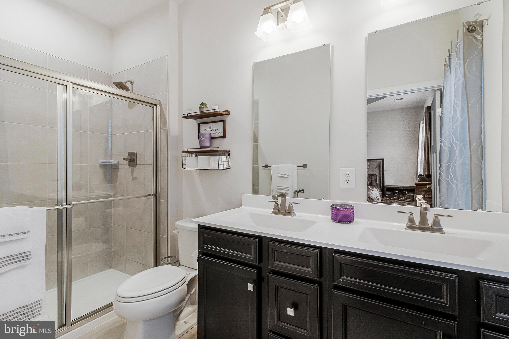 16504 Caribbean Way Accokeek, MD 20607 - Photo 19 of 29 a bathroom with a double vanity sink toilet and shower
