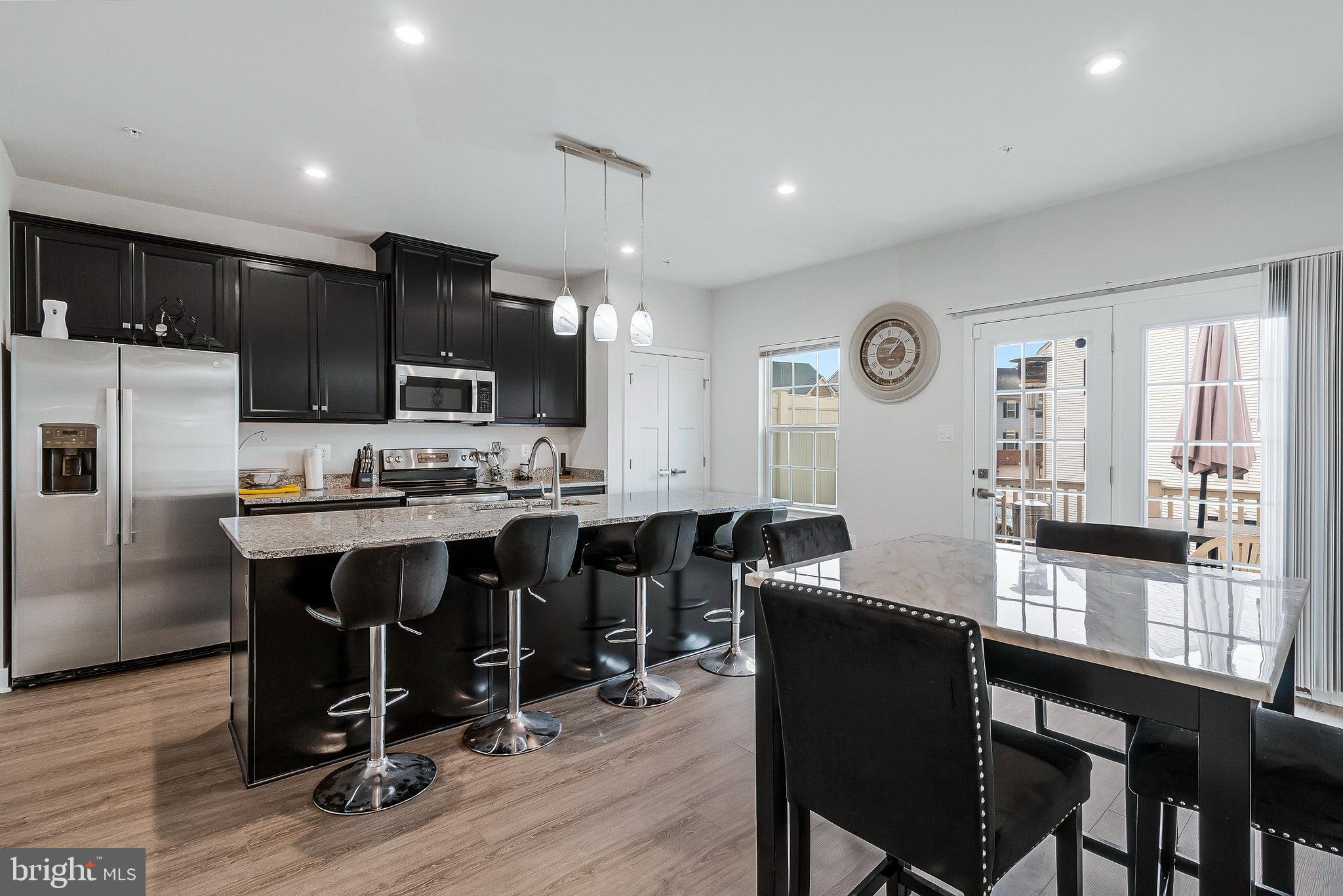 16504 Caribbean Way Accokeek, MD 20607 - Photo 10 of 29 a living room with stainless steel appliances kitchen island granite countertop furniture a dining table and chairs