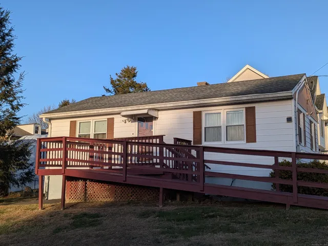 a view of a house with a wooden deck and a yard