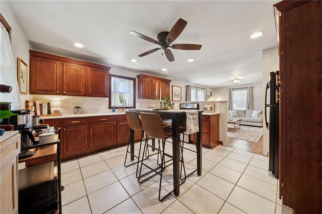 135 Pear Orchard Road Coraopolis, PA 15108 - Photo 12 of 43 a kitchen with stainless steel appliances granite countertop a stove top oven a sink a dining table and chairs with wooden floor