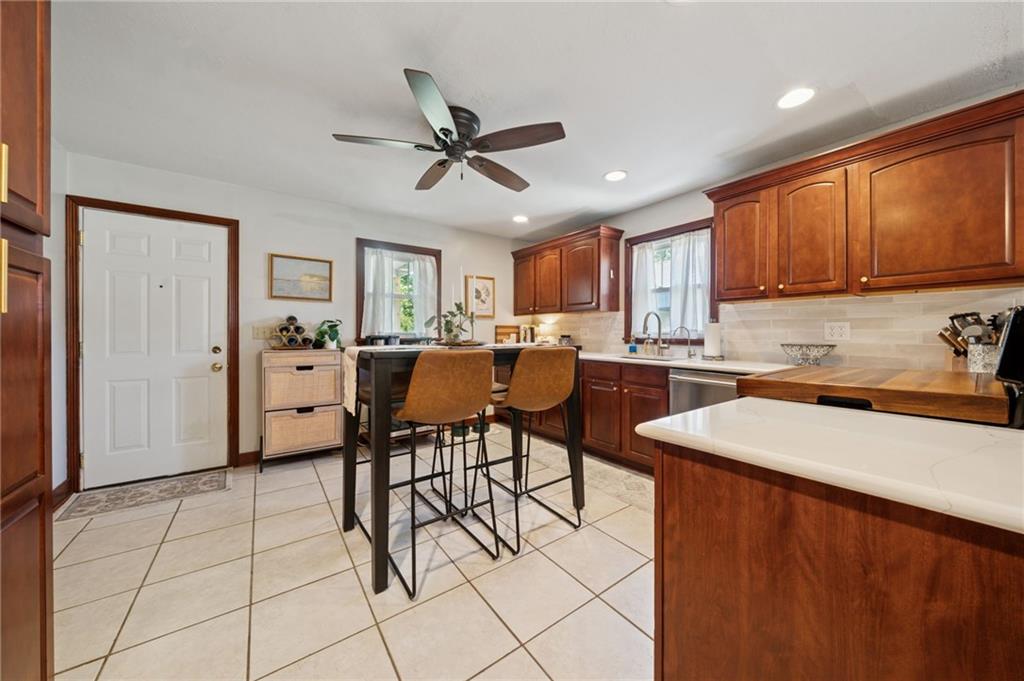 135 Pear Orchard Road Coraopolis, PA 15108 - Photo 13 of 43 a kitchen with stainless steel appliances kitchen island granite countertop a sink a stove a dining table and chairs