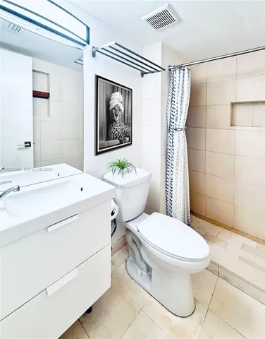 a white toilet sitting next to a bathroom sink