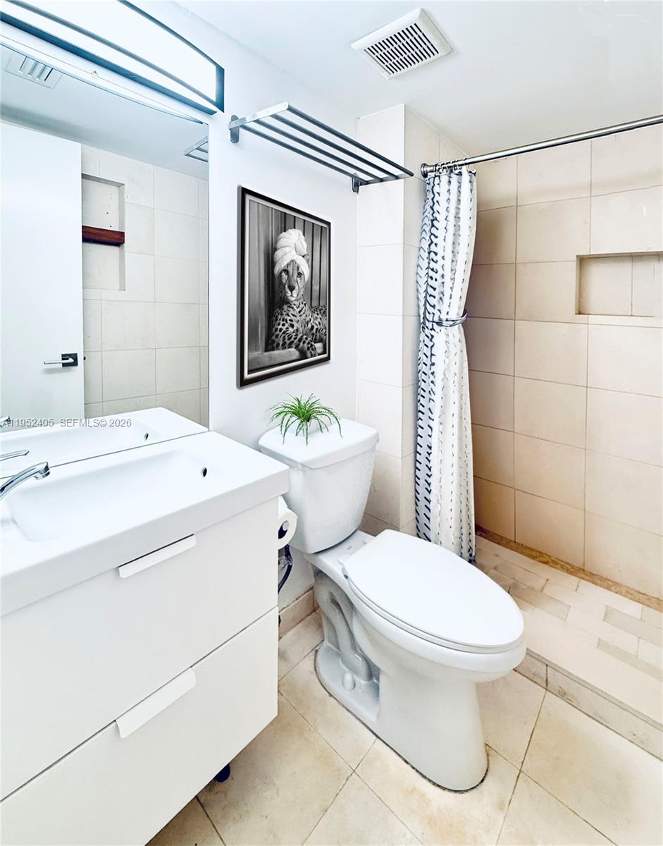 2575 Southwest 27th Avenue, Unit 210 Miami, FL 33133 - Photo 14 of 16 a white toilet sitting next to a bathroom sink