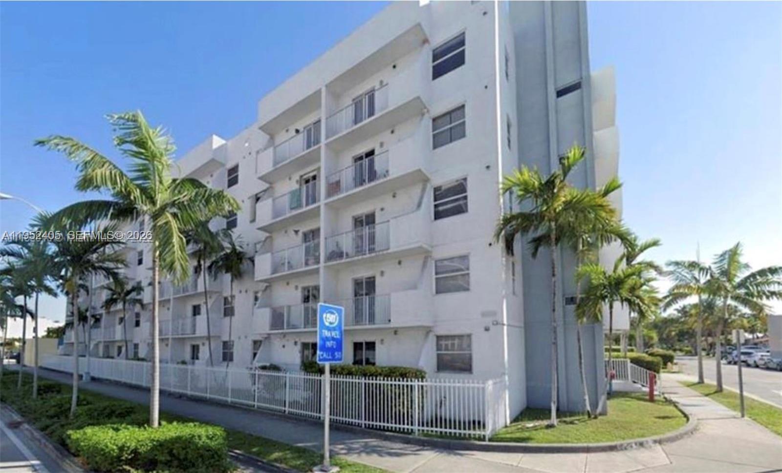 2575 Southwest 27th Avenue, Unit 210 Miami, FL 33133 - Photo 15 of 16 a front view of multi story residential apartment building with yard and sign board