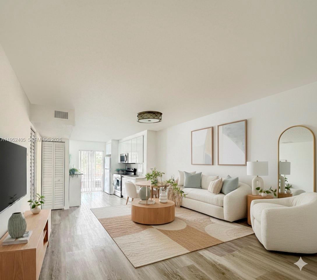 2575 Southwest 27th Avenue, Unit 210 Miami, FL 33133 - Photo 3 of 16 a living room with furniture and a flat screen tv