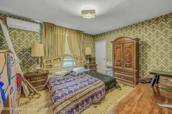 a bedroom with a bed and dresser with mirror