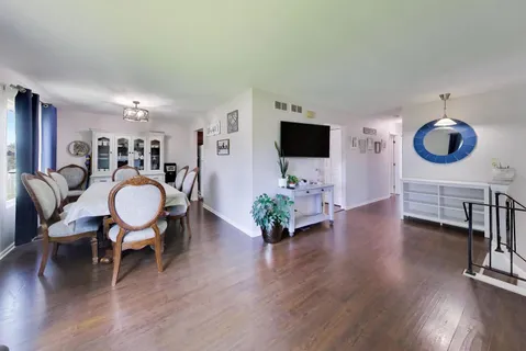 a living room with furniture a dining table and a flat screen tv