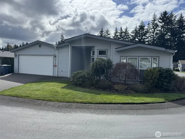 a view of a house with a yard and large tree