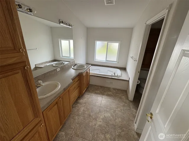 a bathroom with a tub sink and mirror