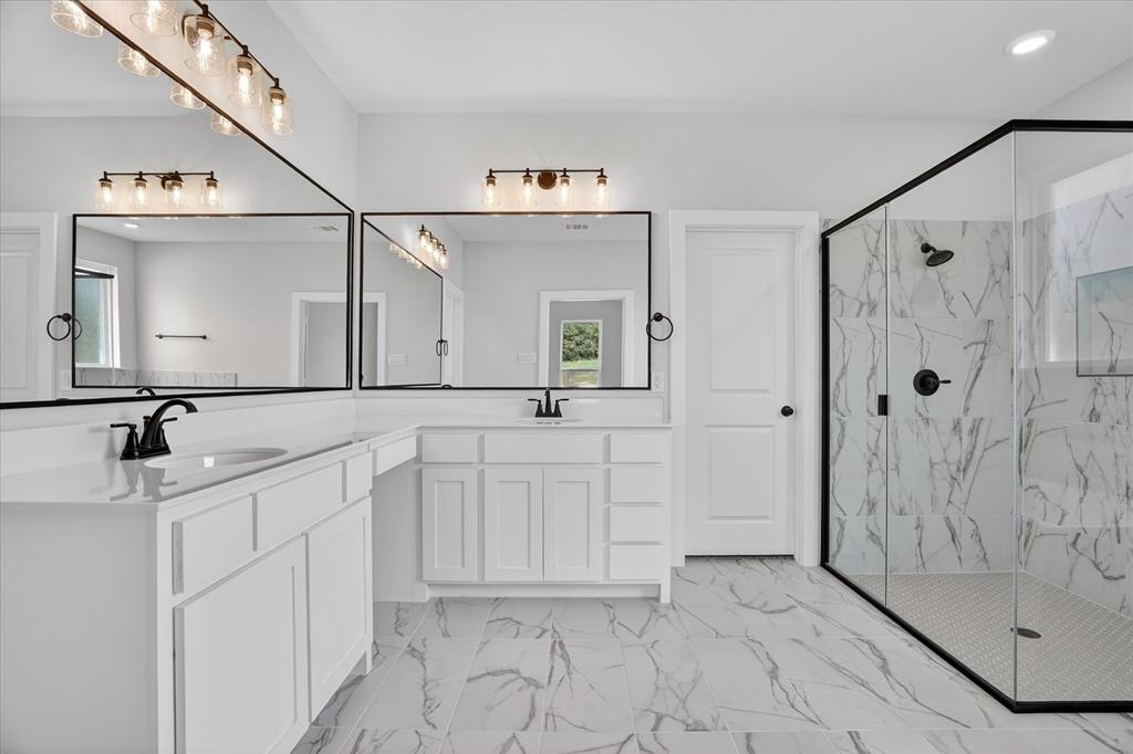 317 Skeen Peak Springtown, TX 76082 - Photo 22 of 31 Spacious bathroom featuring a dual vanity with white cabinetry and countertops, two rectangular mirrors, and matte black fixtures
