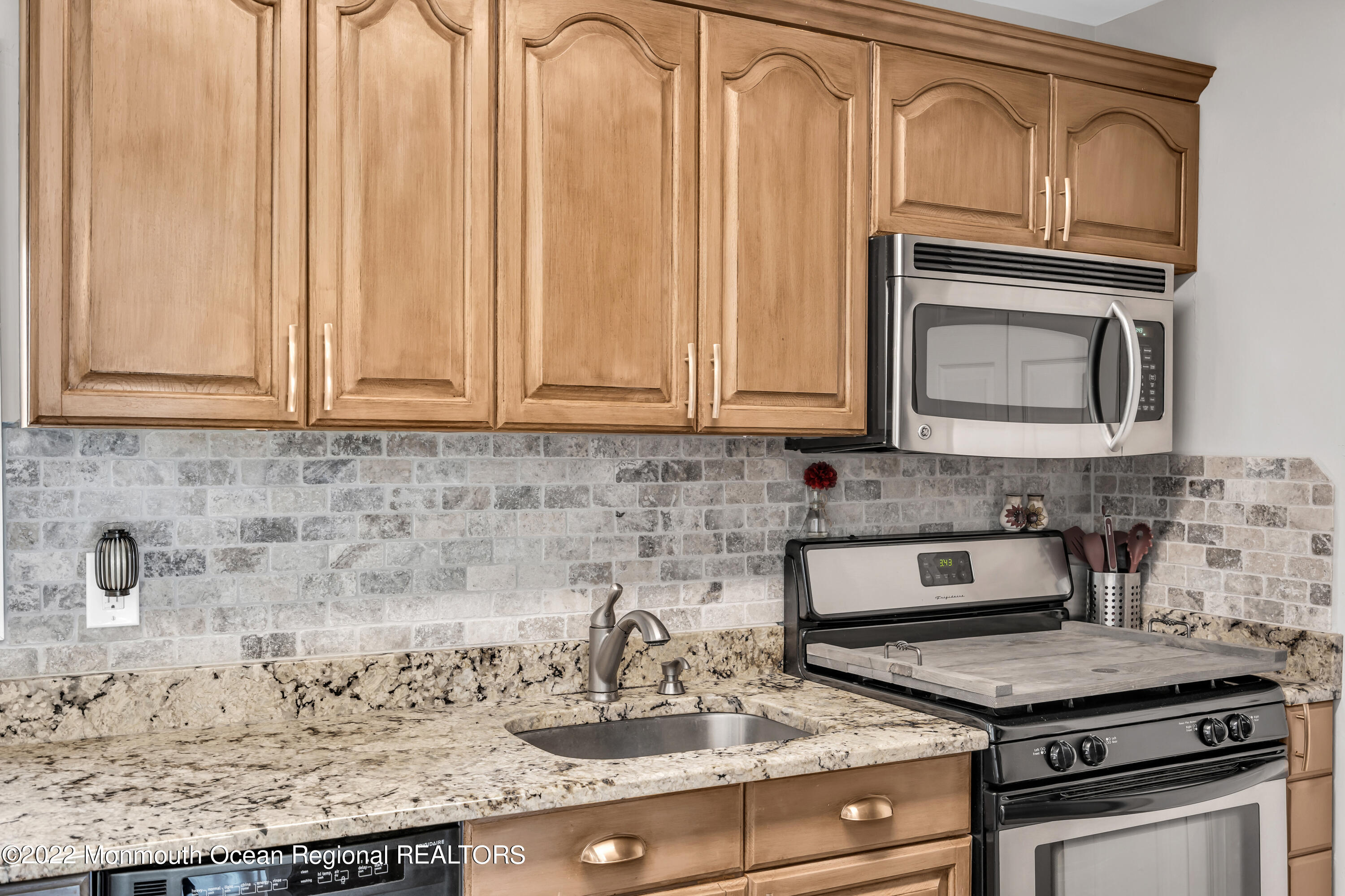19 Lark Lane Brick, NJ 08724 - Photo 42 of 72 a kitchen with granite countertop a stove sink and cabinets