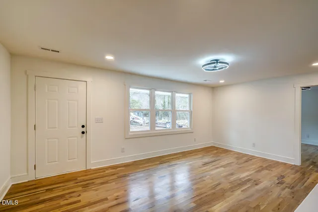 a view of empty room with wooden floor