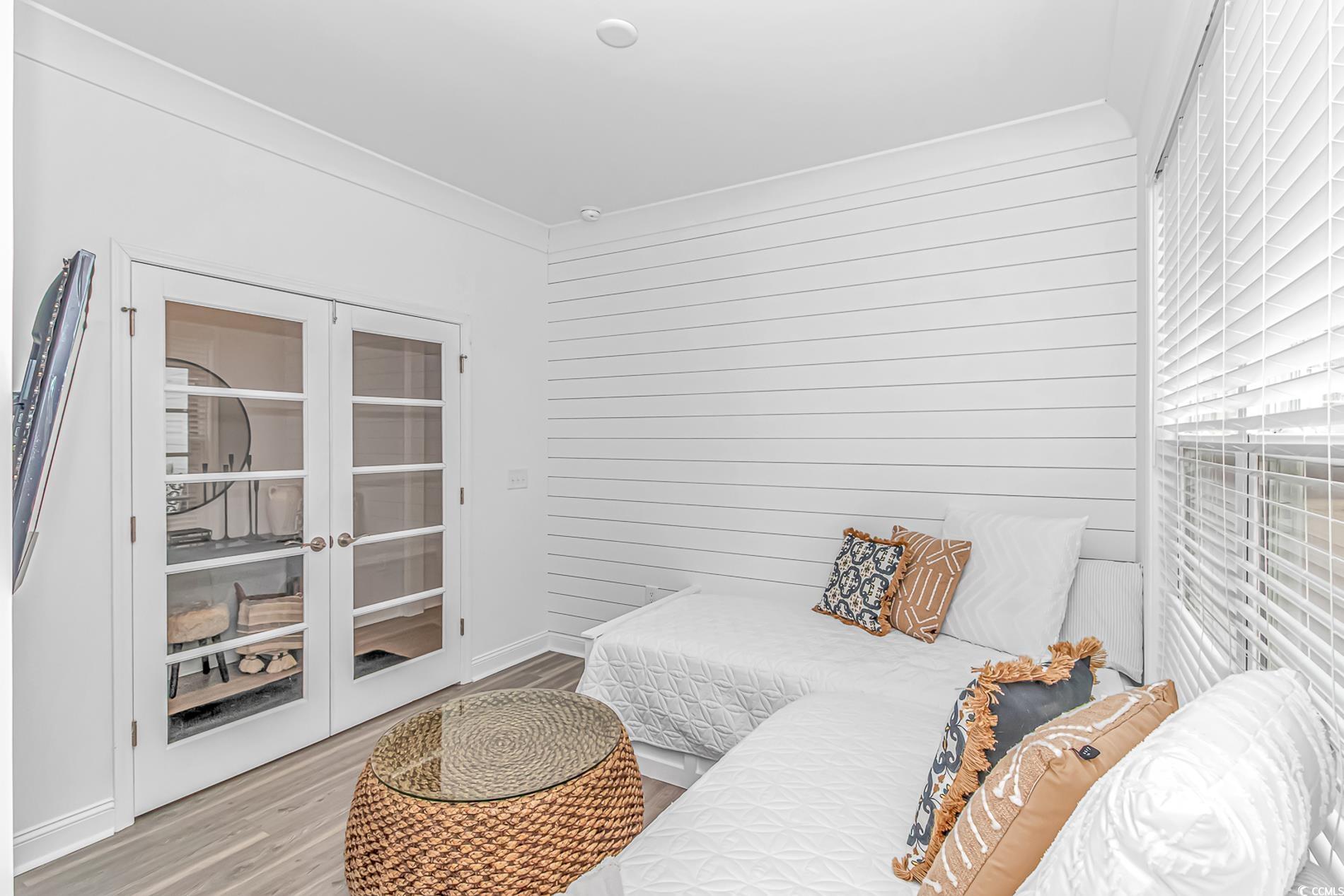 6076 Campanella Street Myrtle Beach, SC 29577 - Photo 13 of 29 Bedroom featuring wood walls, french doors, and light wood-type flooring