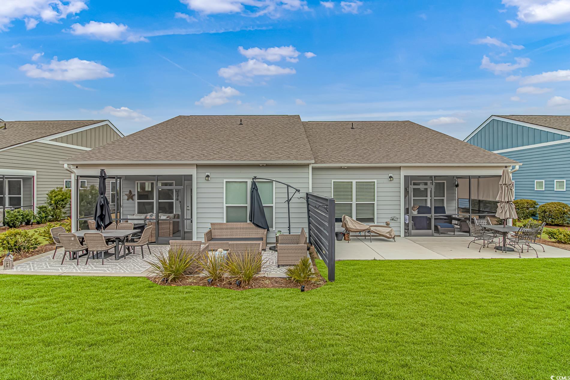 6076 Campanella Street Myrtle Beach, SC 29577 - Photo 25 of 29 Back of property featuring a yard, roof with shingles, a sunroom, and a patio area
