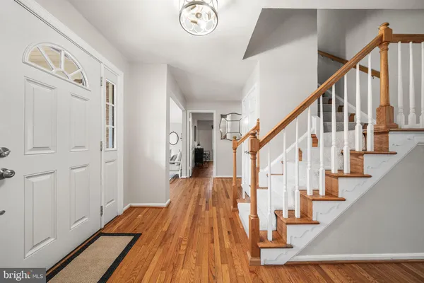 a view of staircase with lots of frames on wall and wooden floor