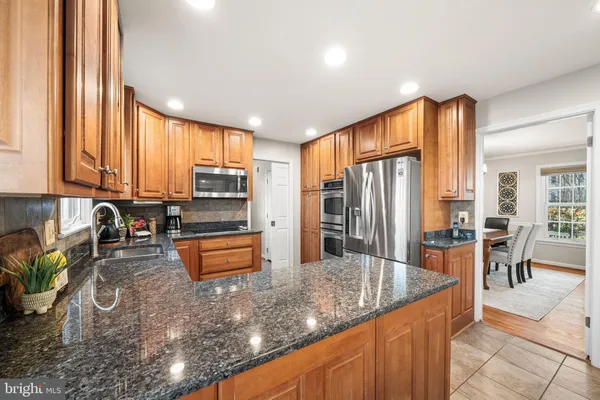 a kitchen with stainless steel appliances granite countertop sink refrigerator and stove