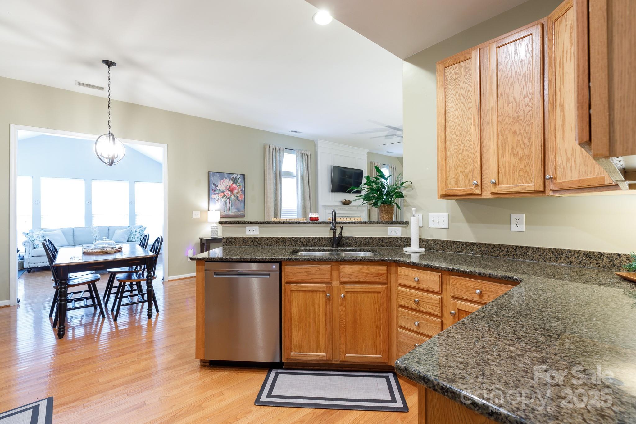 708 Drew Avenue Fort Mill, SC 29708 - Photo 23 of 30 a kitchen with granite countertop a stove a sink and white cabinets with wooden floor