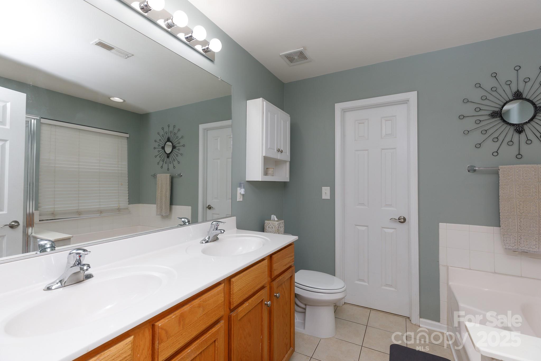 708 Drew Avenue Fort Mill, SC 29708 - Photo 29 of 30 a bathroom with a granite countertop sink a toilet and a mirror