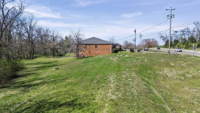 a view of a house with a big yard and a palm tree
