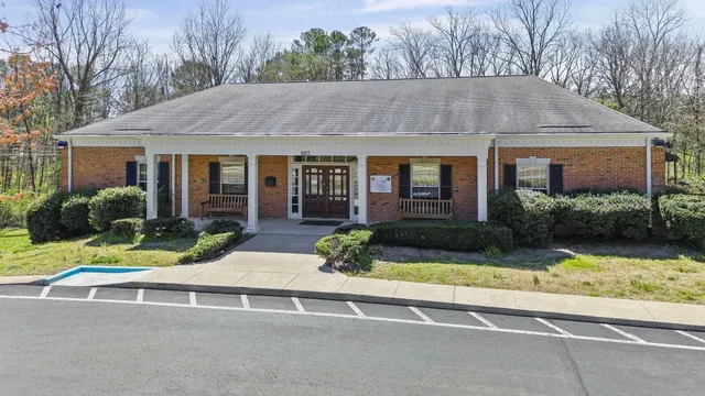 front view of house with a yard and potted plants