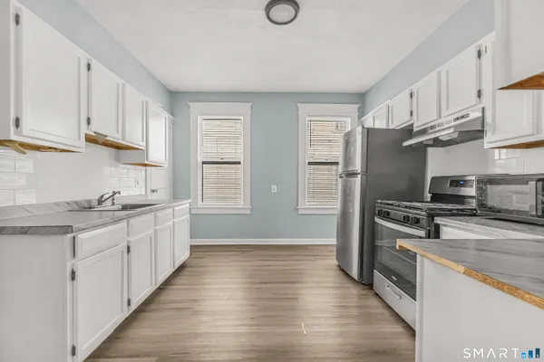a kitchen with stainless steel appliances granite countertop a sink stove and refrigerator