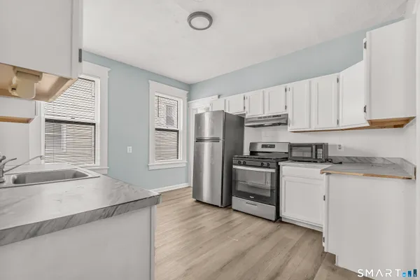 a kitchen with stainless steel appliances granite countertop a refrigerator and a sink