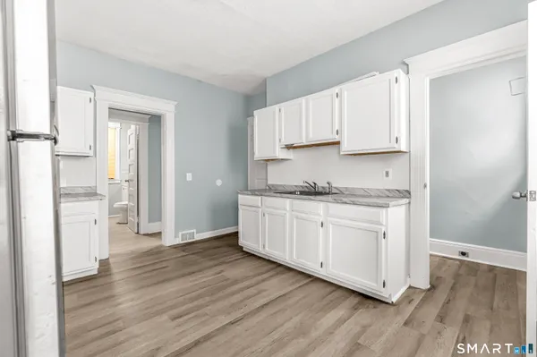 a kitchen with granite countertop white cabinets and white appliances