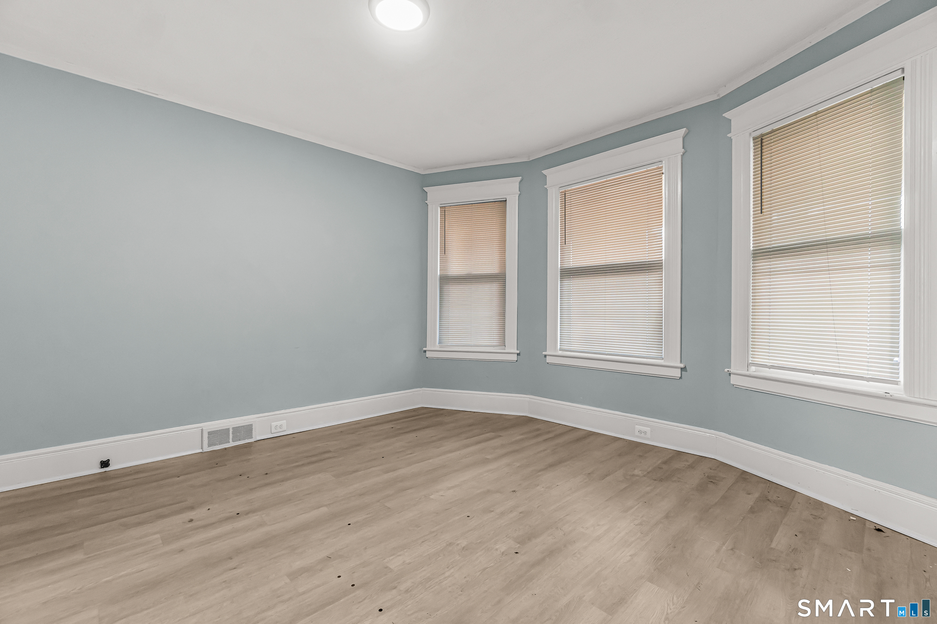 105 Carleton Avenue Bridgeport, CT 06604 - Photo 4 of 26 a view of an empty room with wooden floor and a window
