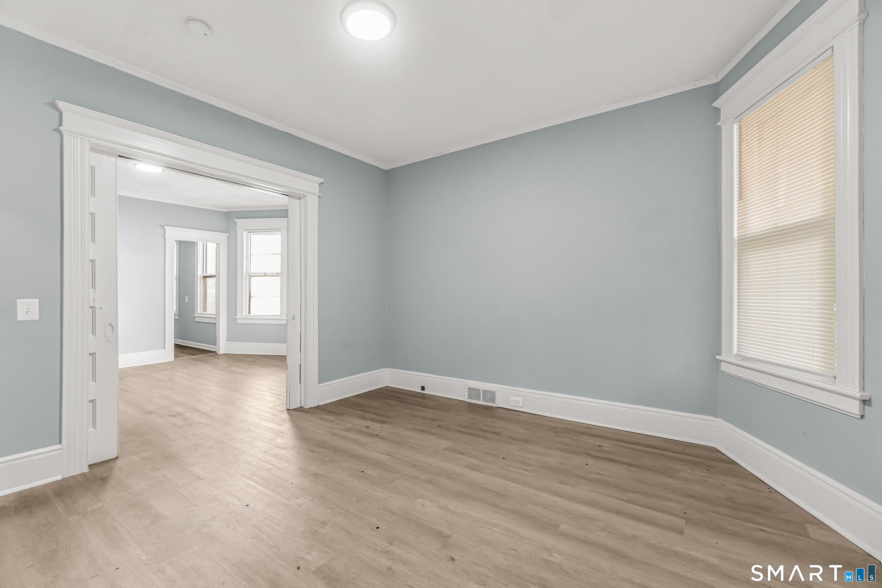 105 Carleton Avenue Bridgeport, CT 06604 - Photo 5 of 26 a view of an empty room with wooden floor and a window