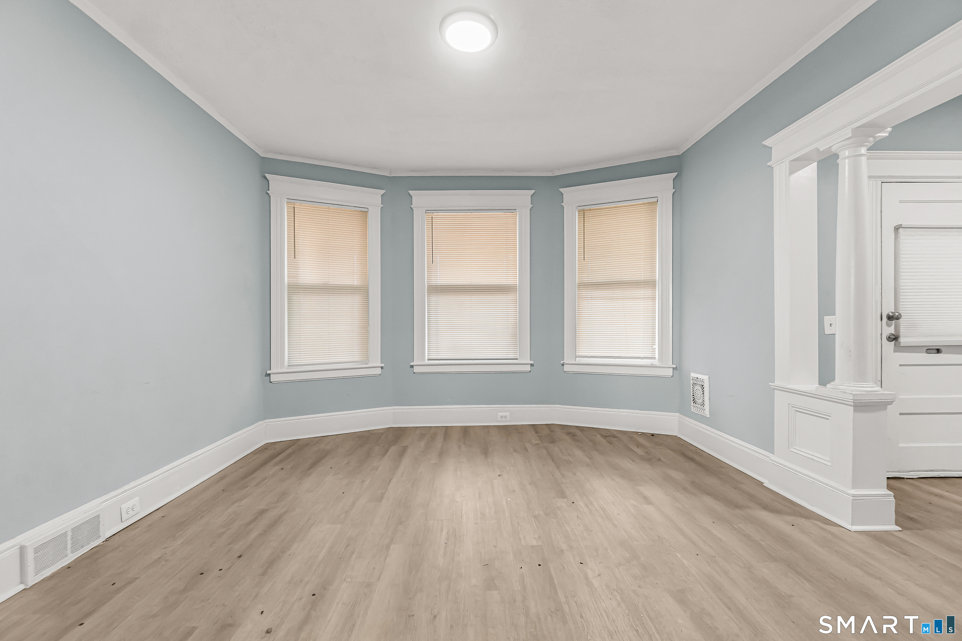 105 Carleton Avenue Bridgeport, CT 06604 - Photo 7 of 26 an empty room with wooden floor and windows
