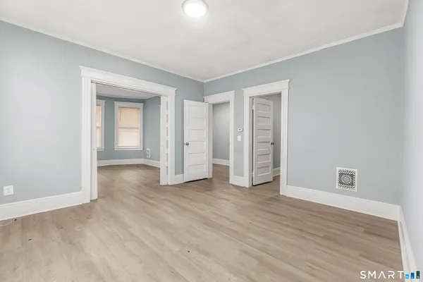 a view of an empty room with window and closet area