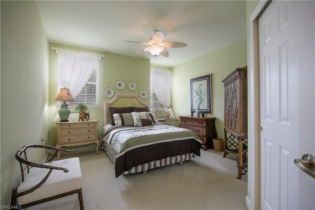 3048 Horizon Lane, Unit 1104 Naples, FL 34109 - Photo 11 of 16 a bedroom with a bed gym equipment and large window