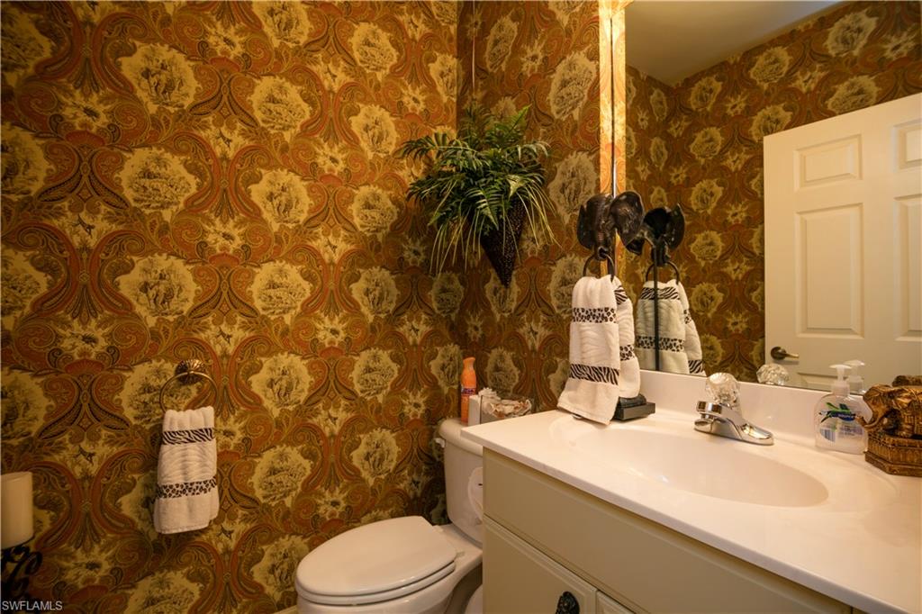 3048 Horizon Lane, Unit 1104 Naples, FL 34109 - Photo 14 of 16 a bathroom with a sink and a mirror