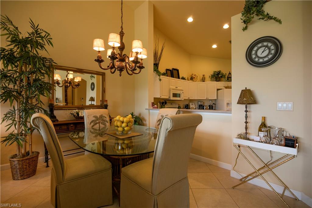 3048 Horizon Lane, Unit 1104 Naples, FL 34109 - Photo 4 of 16 a dining room with furniture and a chandelier