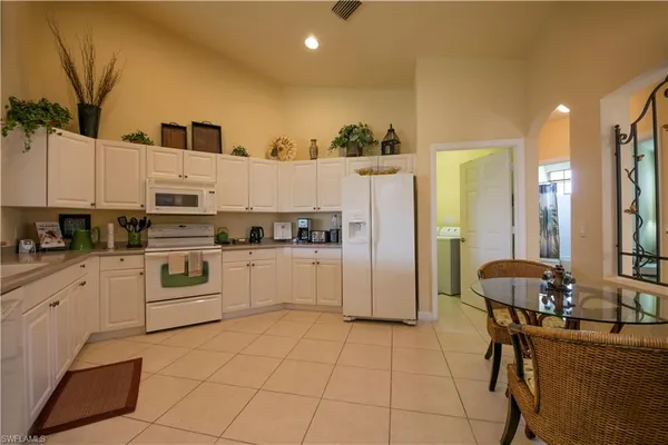 a kitchen with stainless steel appliances kitchen island granite countertop a refrigerator and a stove top oven