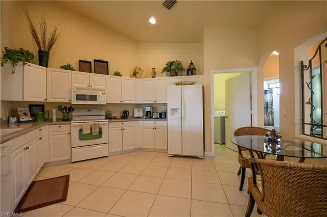 a kitchen with stainless steel appliances kitchen island granite countertop a refrigerator and a stove top oven