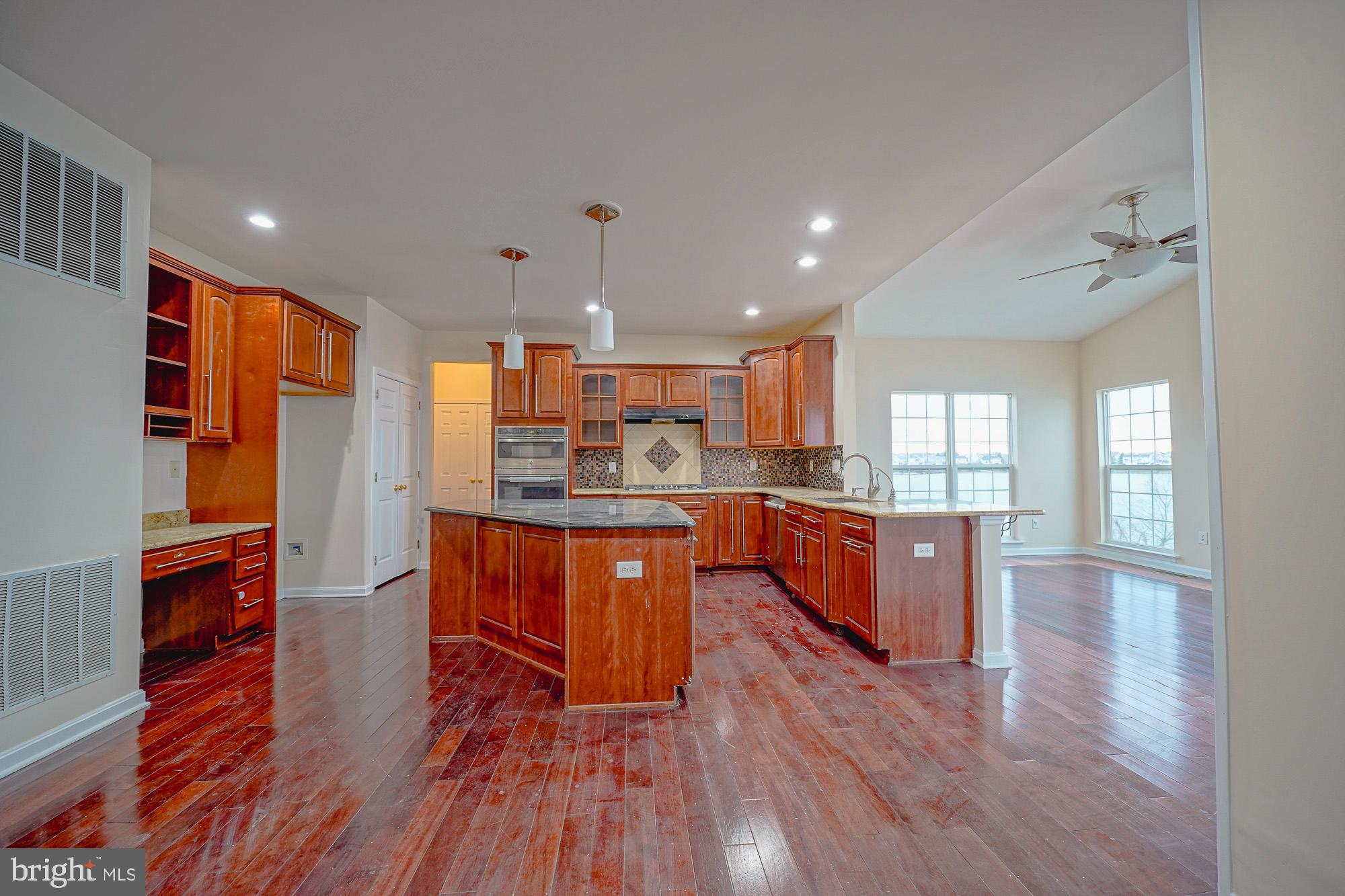 67 Mullen Drive Sicklerville, NJ 08081 - Photo 19 of 57 a open kitchen with stainless steel appliances granite countertop a refrigerator a stove top oven and wooden floors