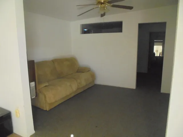 a living room with furniture and a ceiling fan