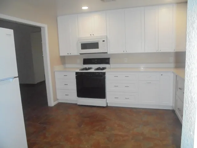 a kitchen with cabinets appliances and a counter top