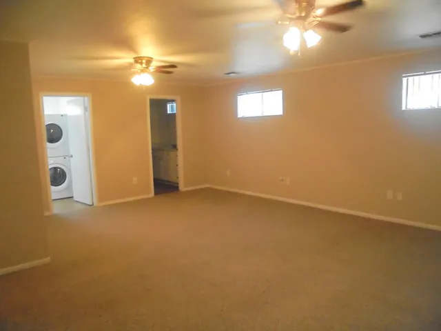 a view of an empty room with a chandelier fan