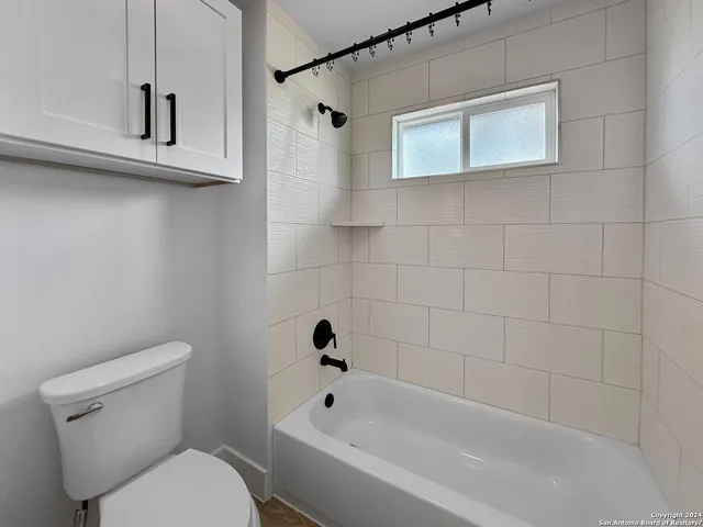 a white toilet sitting next to a bath tub
