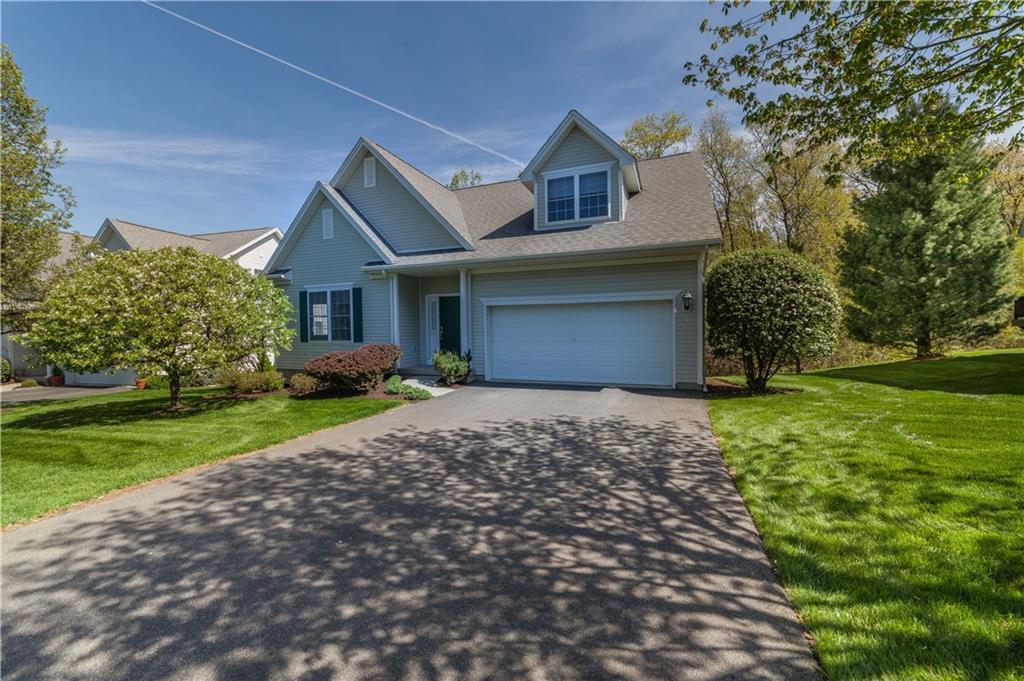 a front view of a house with a yard and trees