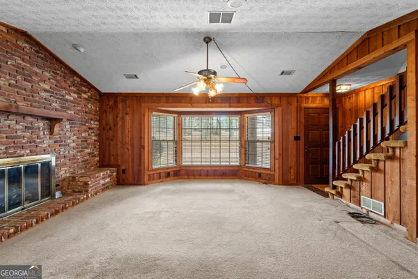 a view of an empty room with a fireplace and a window