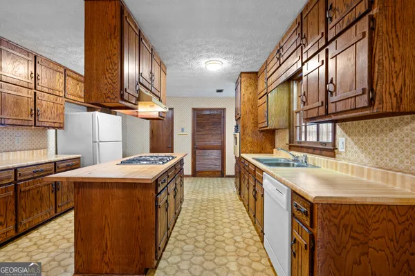 a kitchen with stainless steel appliances granite countertop a stove a sink and a refrigerator