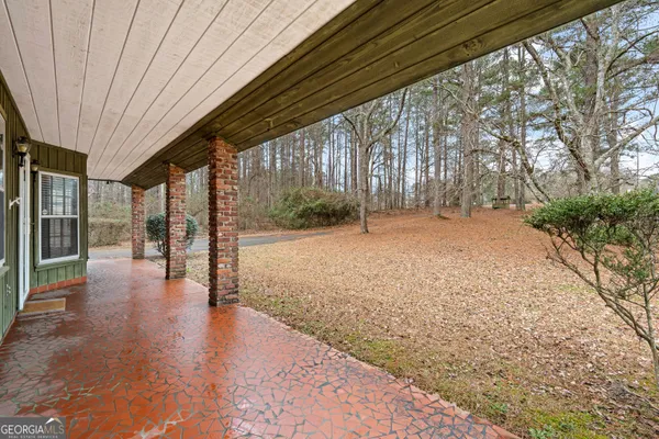a view of empty room with wooden floor and fence
