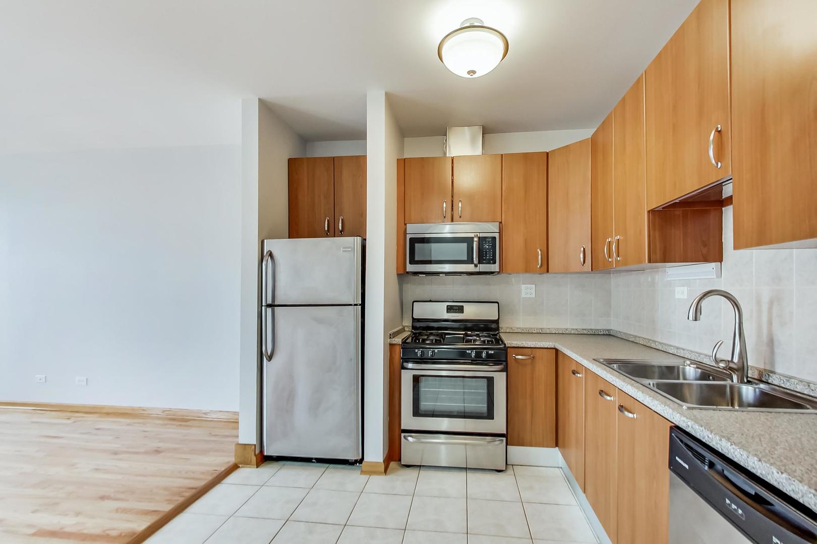 2032 West Division Street, Unit 301N Chicago, IL 60622 - Photo 6 of 12 a kitchen with stainless steel appliances a refrigerator sink and cabinets