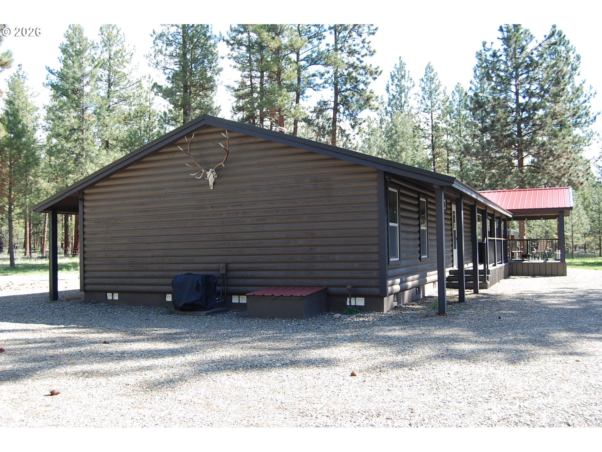 38987 Deer Creek Road Baker City, OR 97814 - Photo 3 of 45 a backyard of a house with large trees and wooden fence