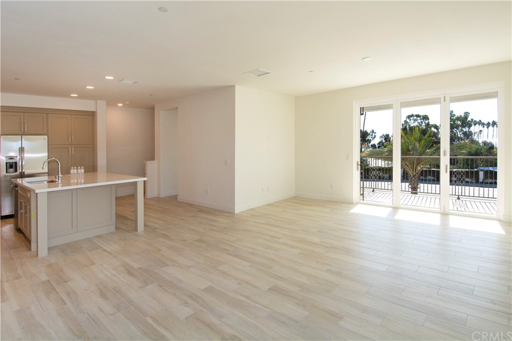 3197 Doheny Way Dana Point, CA 92629 - Photo 17 of 28 a view of a kitchen with kitchen island a sink wooden floor and a large window