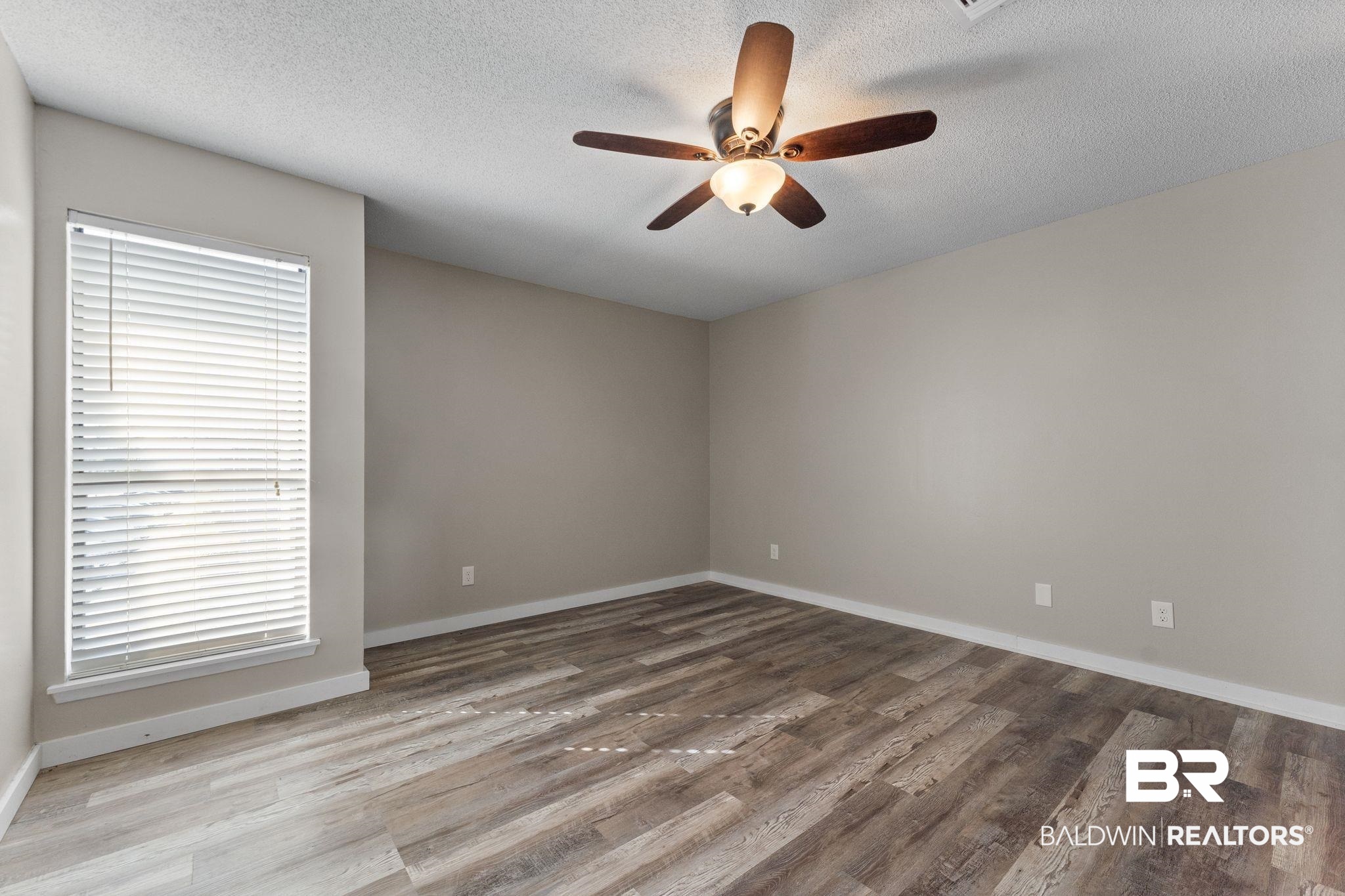 128 West Satsuma Avenue, Unit 128 Foley, AL 36535 - Photo 17 of 41 Empty room with ceiling fan, light wood-type flooring, and a textured ceiling
